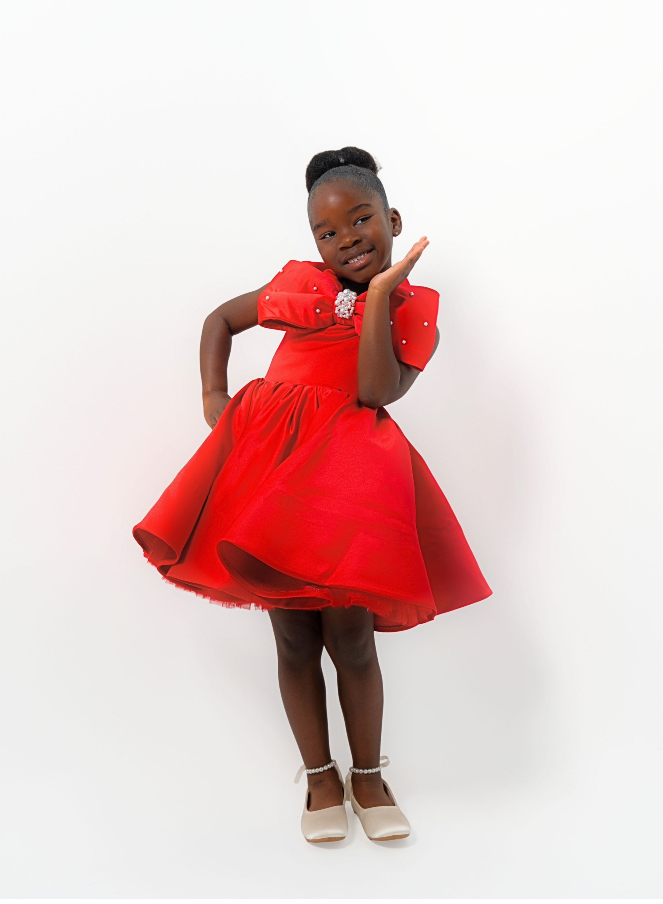 Girl in red satin dress with rhinestone bow, styled for Valentine’s Day or Christmas party